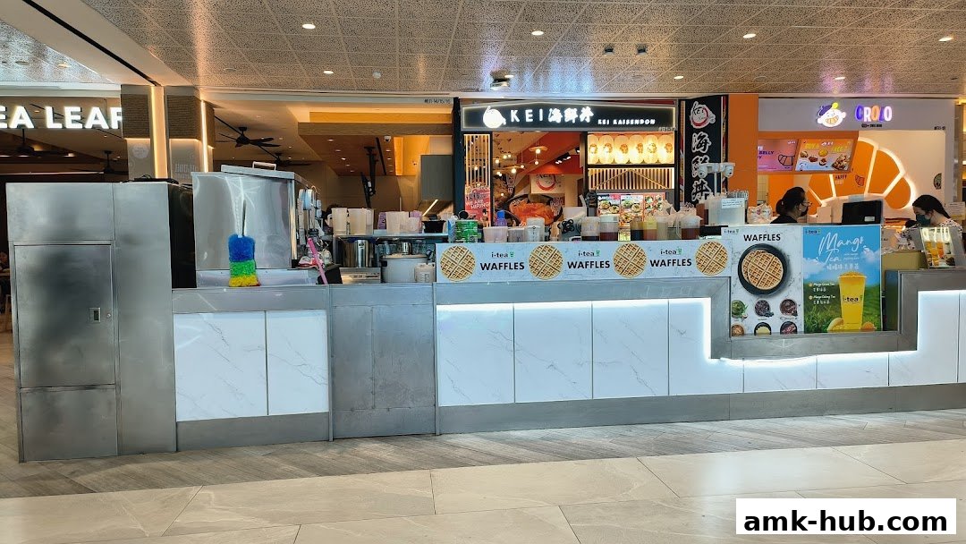 A modern beverage and waffle stall with bright signage and illuminated displays.