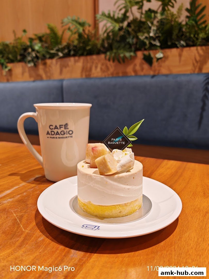 A delicate cake with fruit and cream, served with a coffee mug at Paris Baguette.
