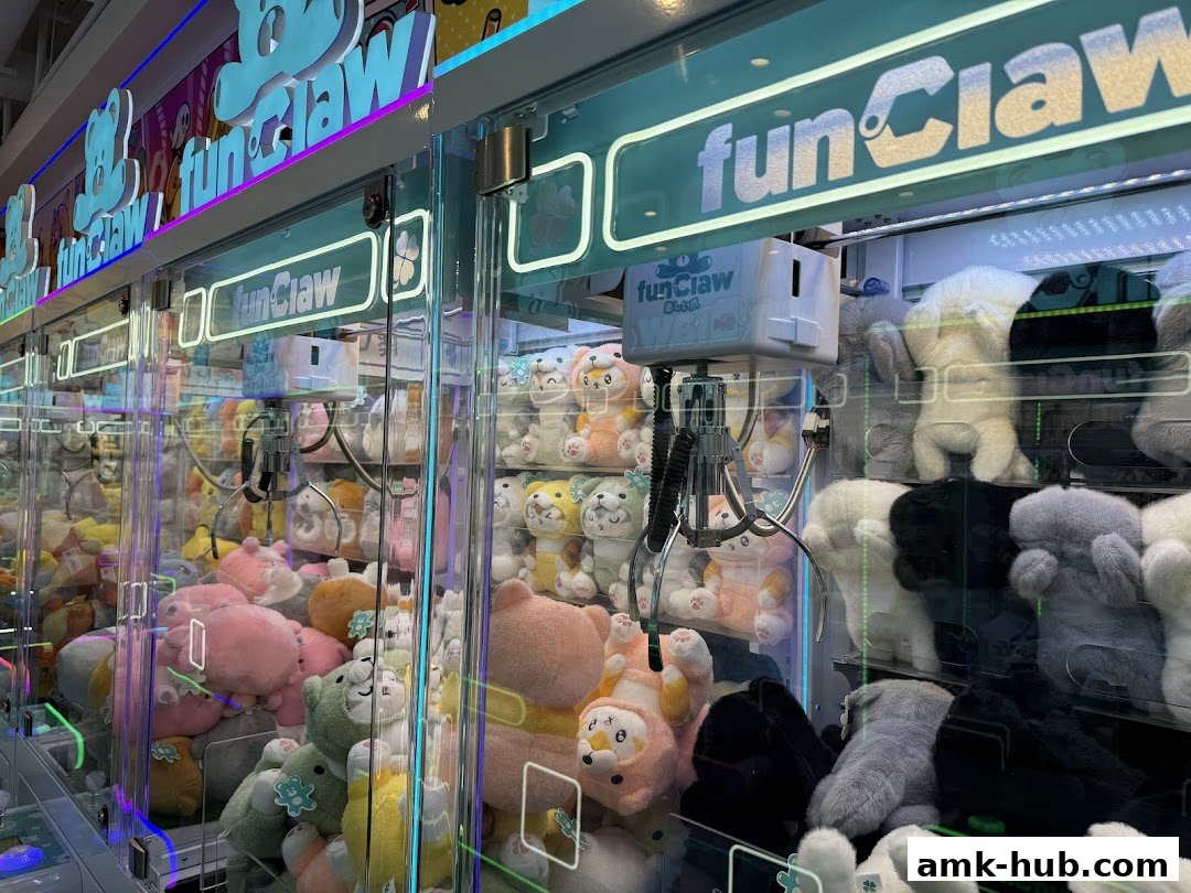 A row of brightly lit claw machines filled with various plush toys.
