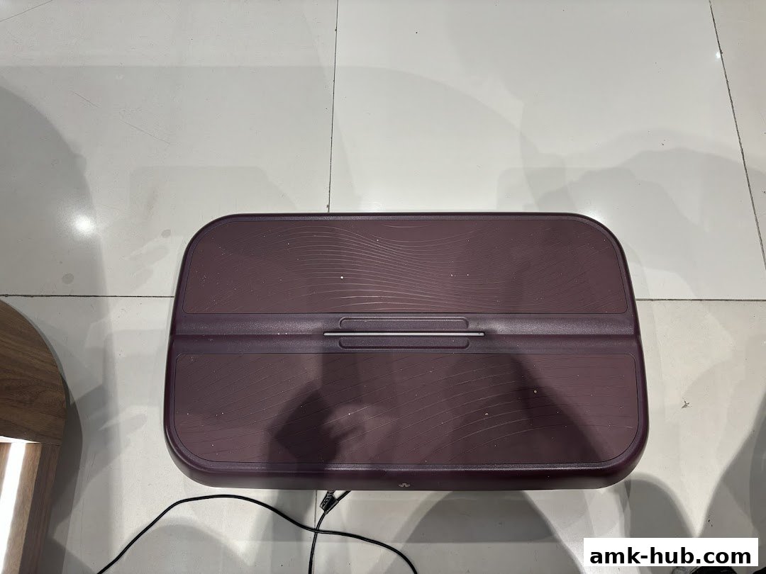 A close-up shot of a purple vibrating fitness platform with a silver handle.