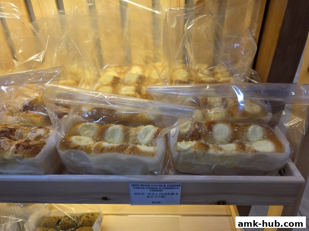 A close-up of freshly baked mini buns filled with cream cheese and sprinkled with parmesan.