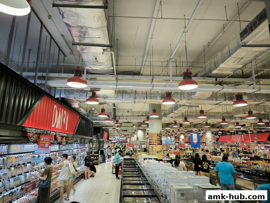 Interior view of a well-lit supermarket with aisles of products and shoppers.