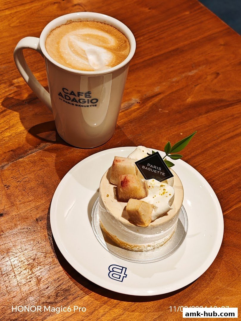 A delicious cake and a cup of coffee with latte art on a wooden table.