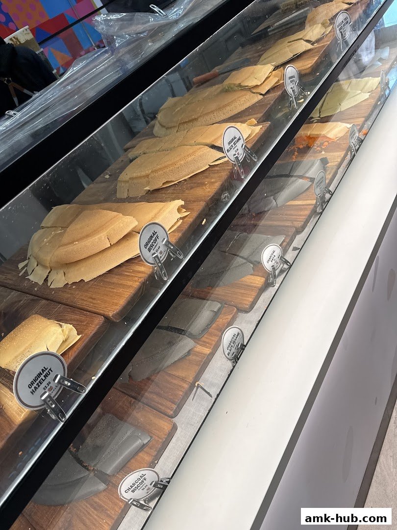 A display case filled with various flavors of pancakes, neatly arranged on wooden boards.