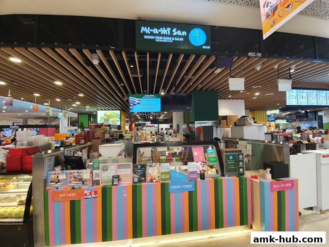 The Maki-San shop front with colorful stripes and a display of sushi and salad.