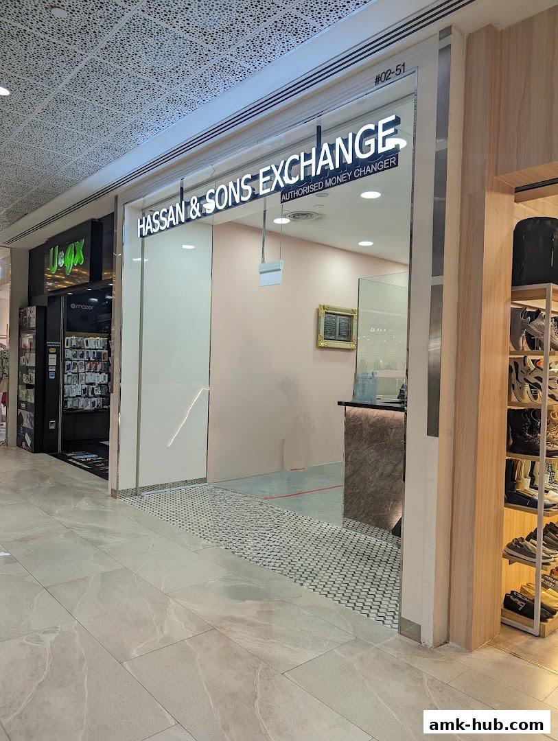 The exterior of Hassan & Sons Exchange, an authorized money changer, with its illuminated signage.