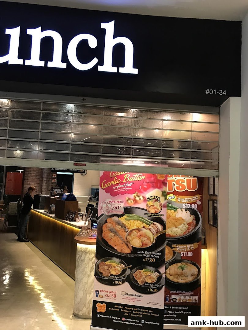 The entrance of a Pepper Lunch restaurant with a promotional banner displaying seafood dishes.