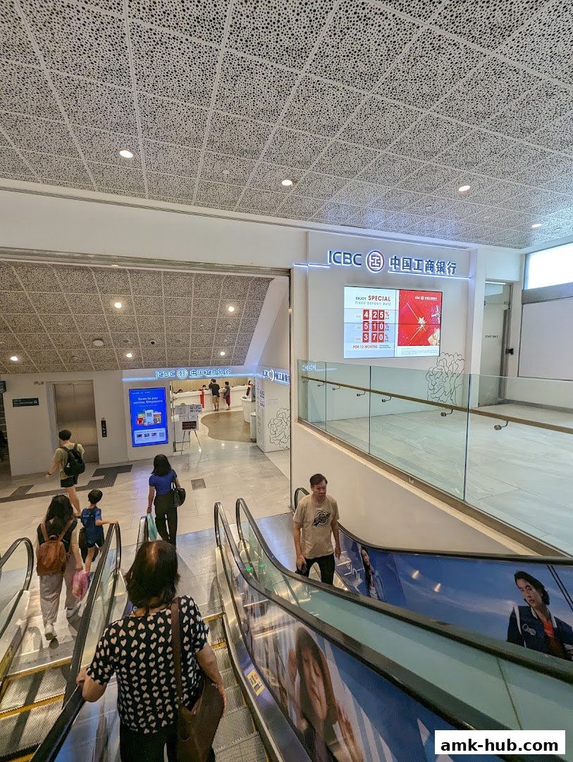 People on escalators near the ICBC bank entrance with a special deposit rate display.