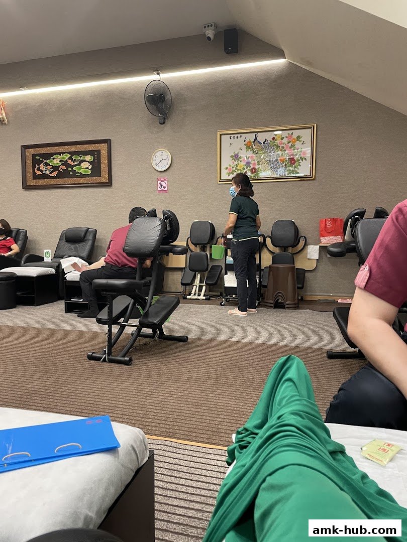 Interior of a foot reflexology center with massage chairs and people receiving treatments.