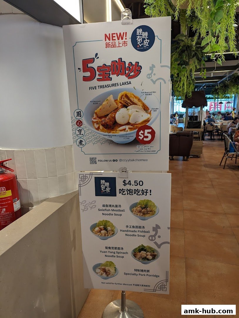A menu board displays various noodle soups and a pork porridge from Kopitiam.