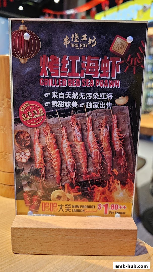 A menu display featuring grilled red sea prawns with promotional text and pricing.