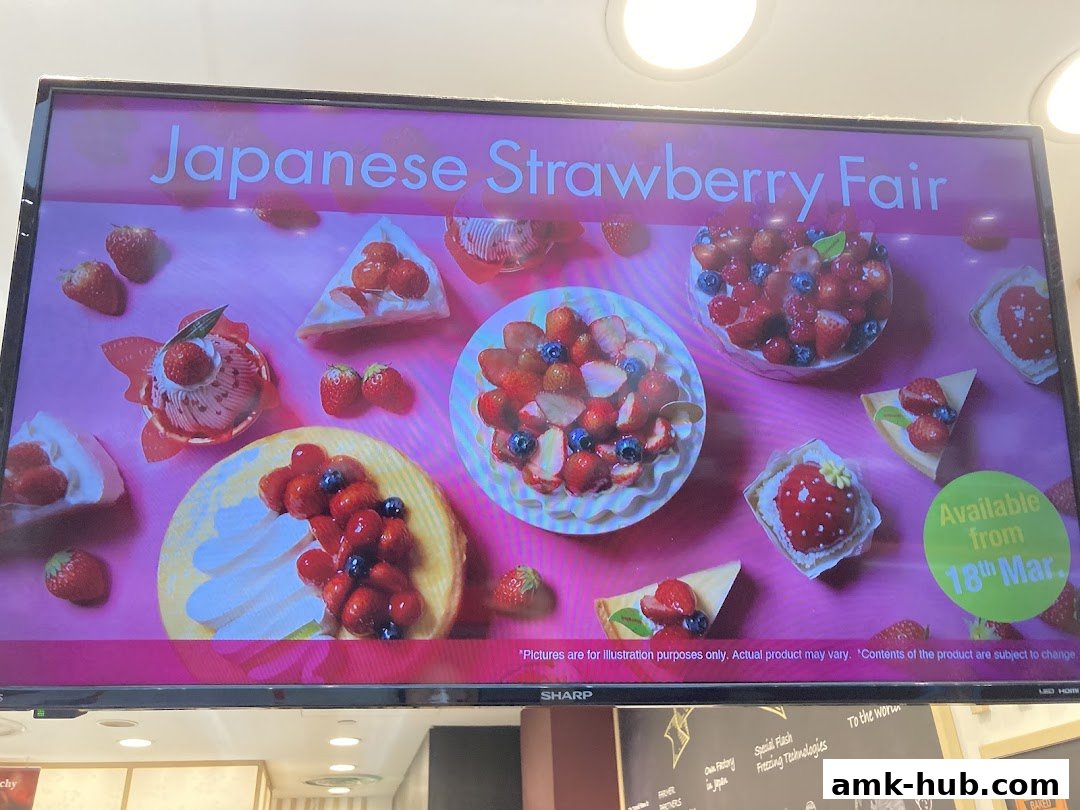 A digital display showcasing various strawberry desserts and announcing a Japanese Strawberry Fair.