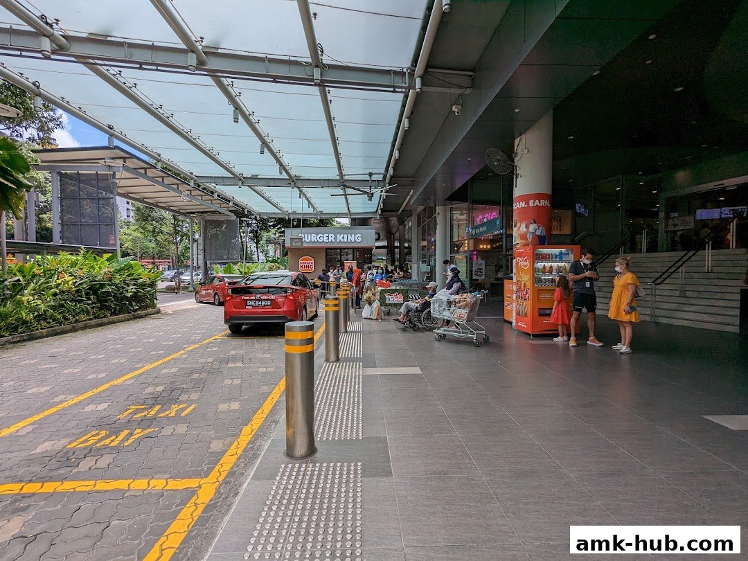 A Burger King storefront with a taxi stand and people waiting outside.