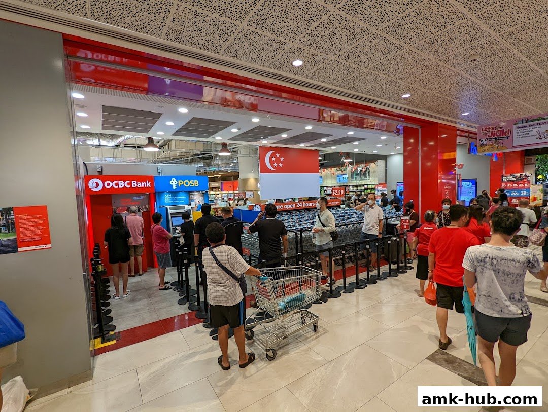 People queuing at OCBC and POSB ATMs outside a Fairprice Xtra supermarket.