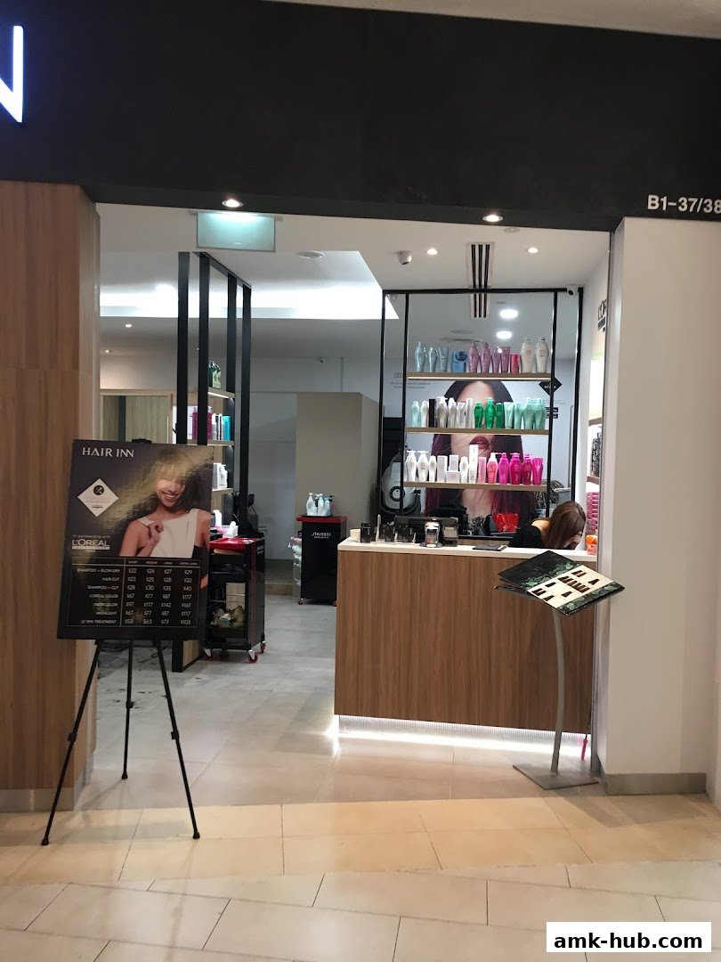 The entrance to Hair Inn salon, featuring a price list and shelves stocked with hair products.