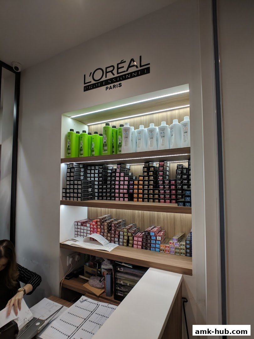 Hair salon interior with shelves stocked with L'Oréal hair color products and bottles.