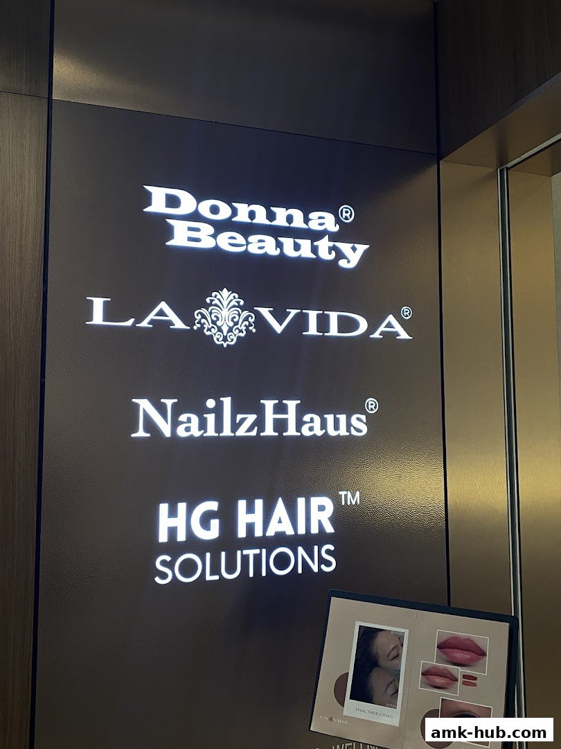 A sign displays multiple beauty and hair service brands, with a small brochure at the bottom.