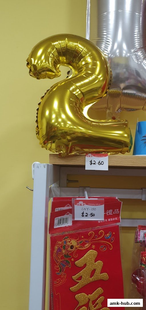 Gold number '2' balloon and Chinese New Year decorations with price tags.