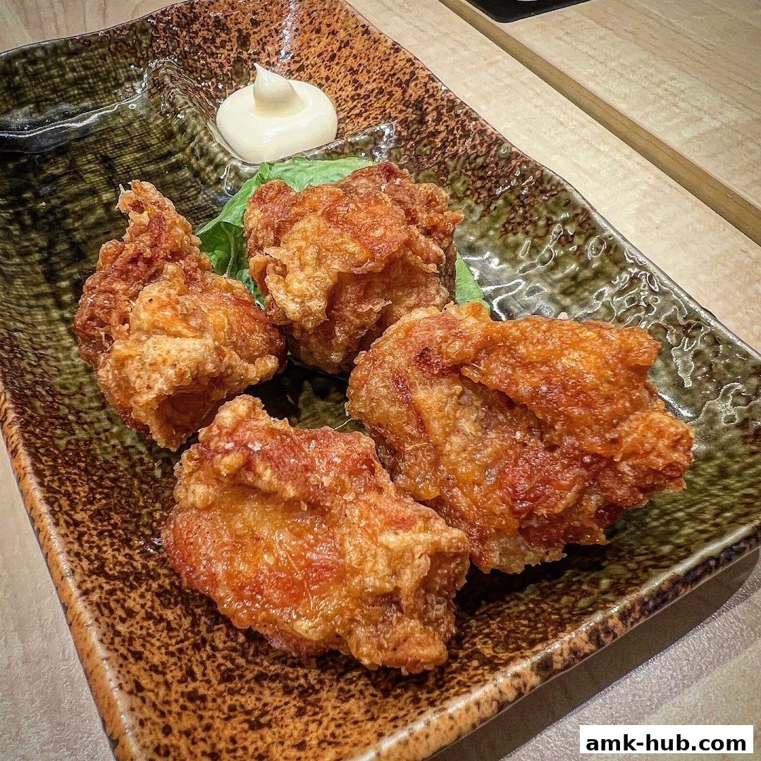A plate of crispy fried chicken pieces with a dollop of mayonnaise.