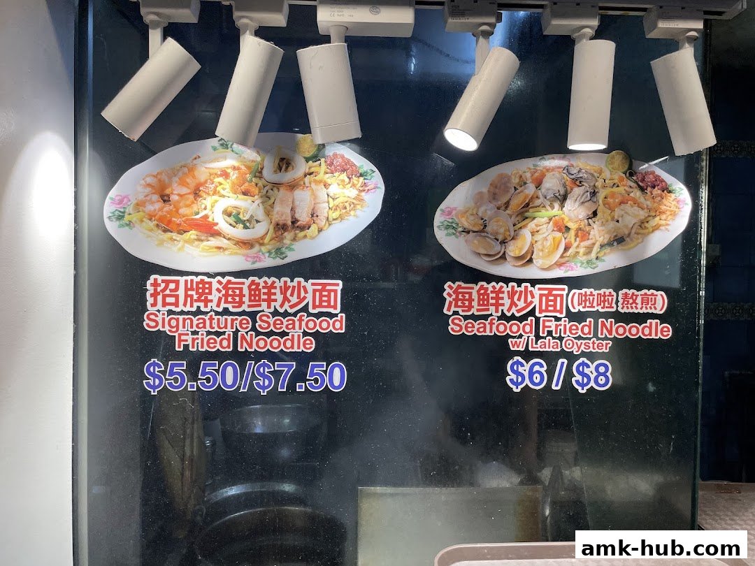 Two plates of seafood fried noodles with prices displayed.