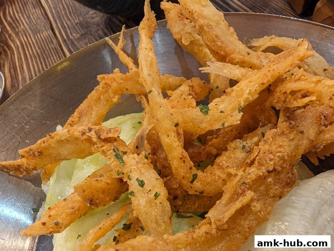 A close-up shot of crispy fried calamari served on a bed of lettuce.