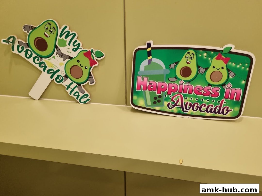 Two signs featuring cartoon avocados, one with text 'My Avocado Hall' and another with 'Happiness in Avocado'.