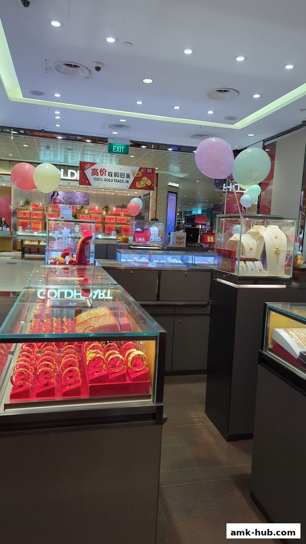 Interior view of a jewelry store showcasing gold bracelets and necklaces, with balloons and a 'Gold Trade-In' sign.