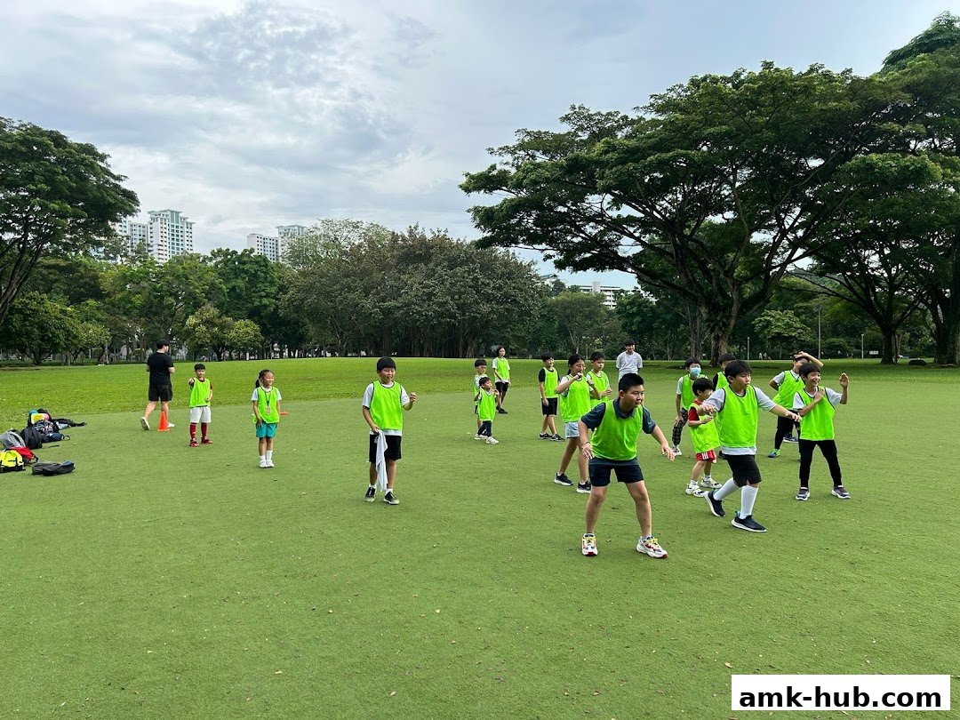 Children in bright green vests practicing Taekwondo outdoors on a grassy field.