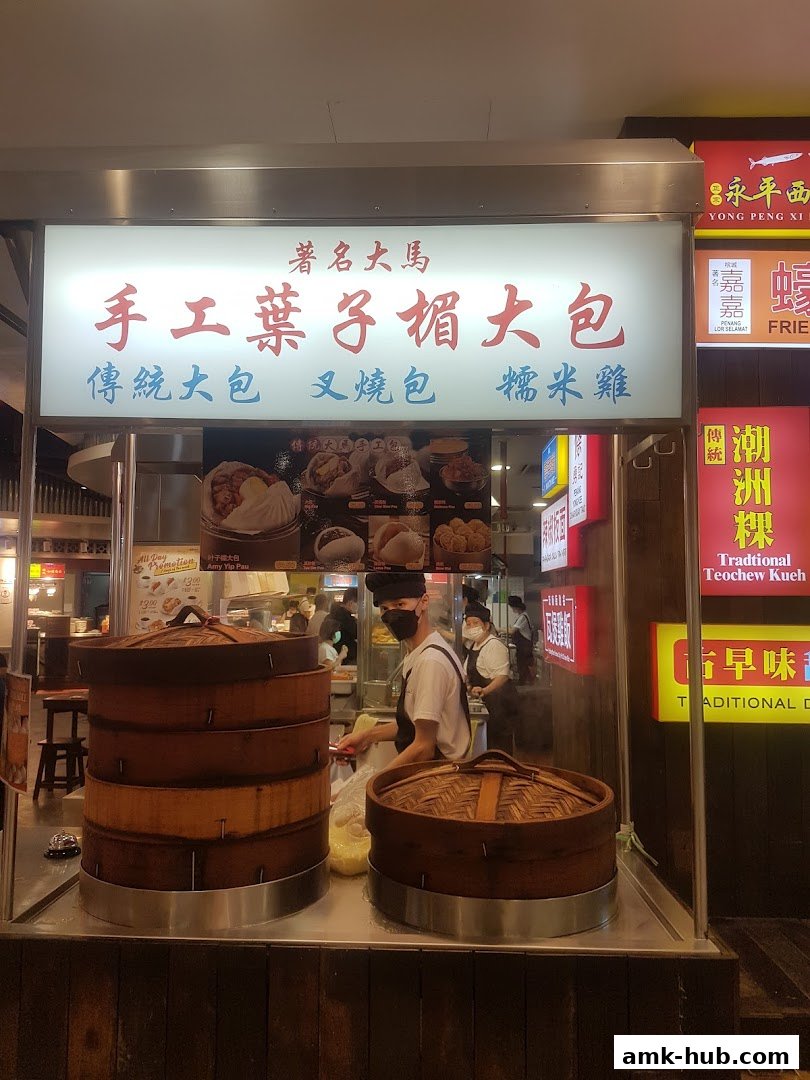 A food stall with steaming baskets and a sign advertising traditional Chinese buns and rice.