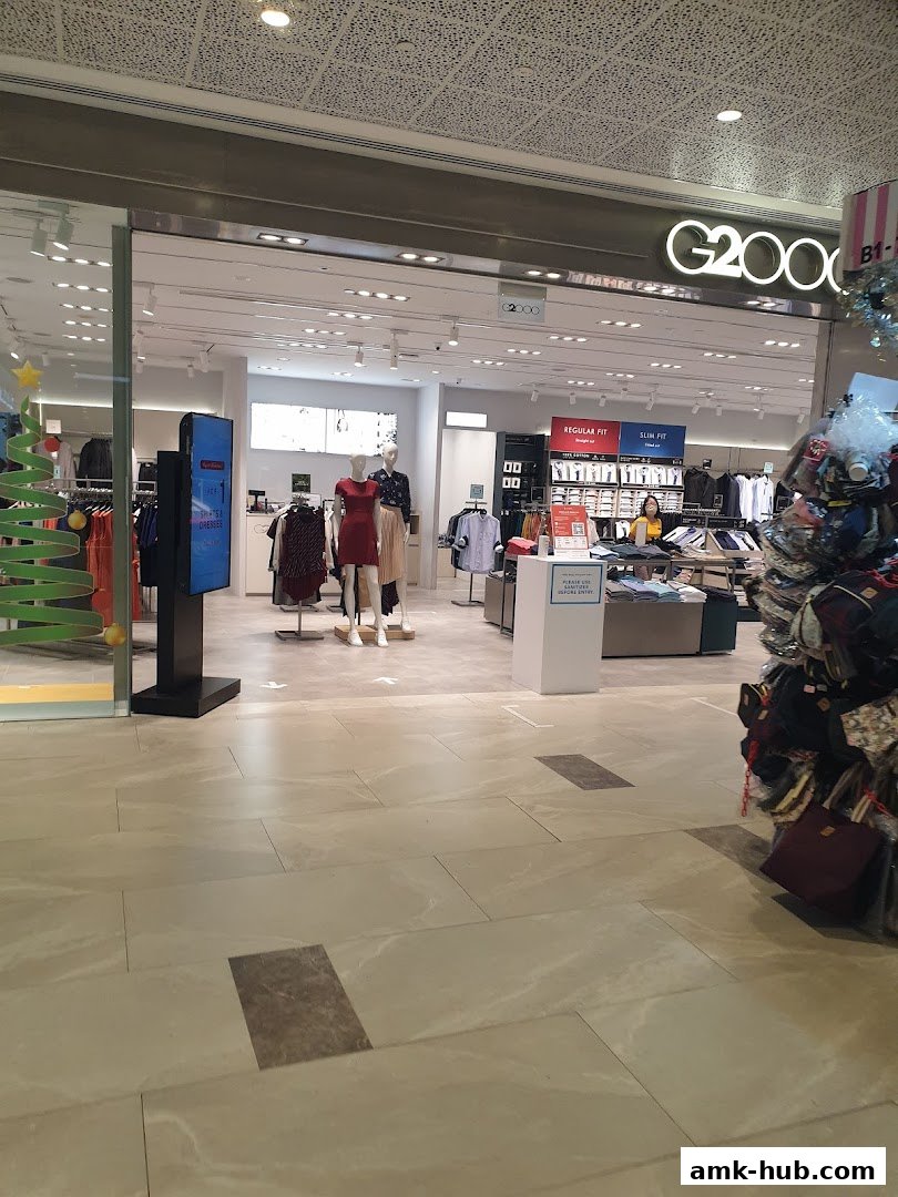 The entrance of a G2000 clothing store with mannequins and merchandise displayed.