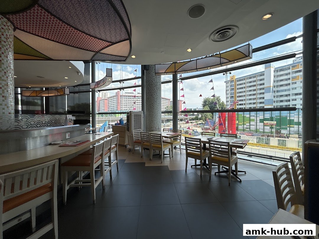 Interior view of Ichiban Sushi Ang Mo Kio with seating and large windows overlooking the city.