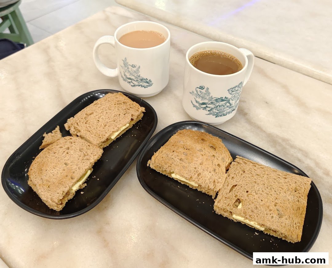 Two servings of kaya toast with butter and two cups of coffee or tea.