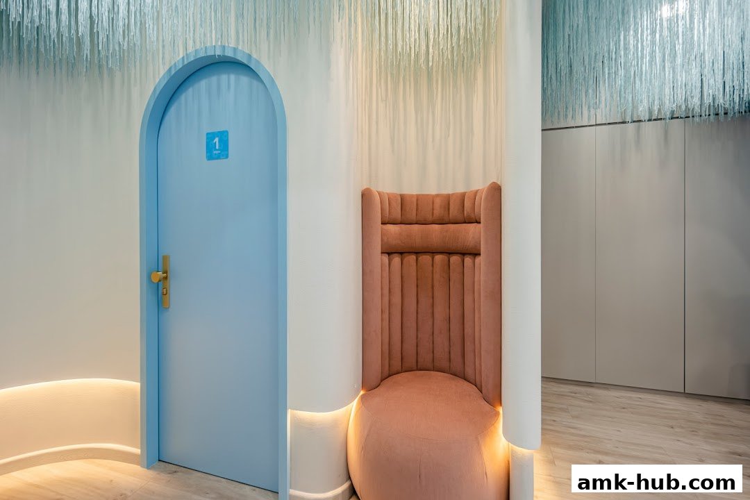 A stylish waiting area with a blue arched door and a plush pink chair.