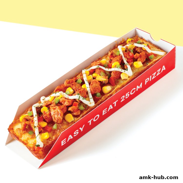 A long, rectangular pizza with chicken, corn, and peppers, drizzled with white sauce.