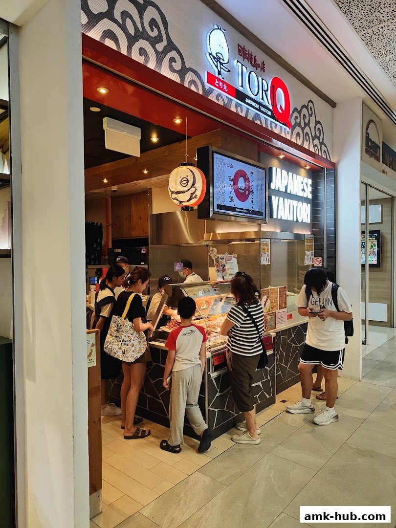 Customers ordering Japanese yakitori at the TORI-Q shop counter.