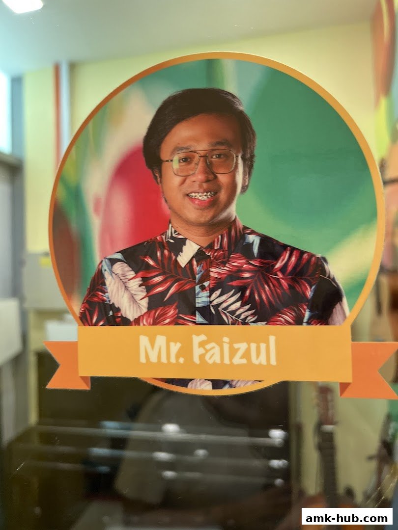 A portrait of Mr. Faizul, an instructor at Aureus Academy, wearing a floral shirt.