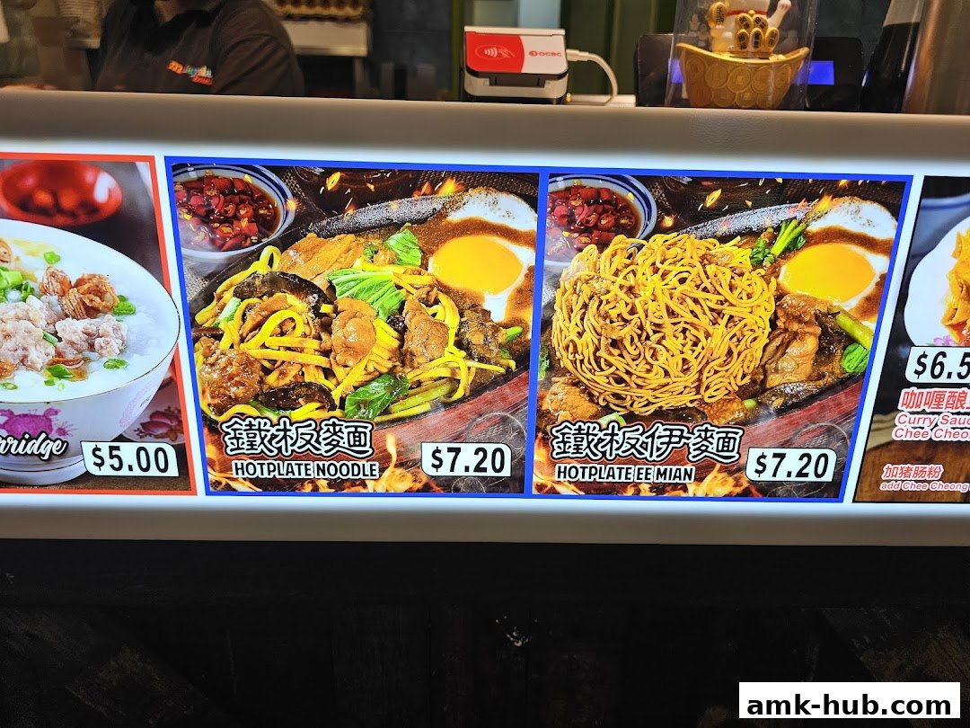 A brightly lit menu display showcasing various noodle dishes and porridge.