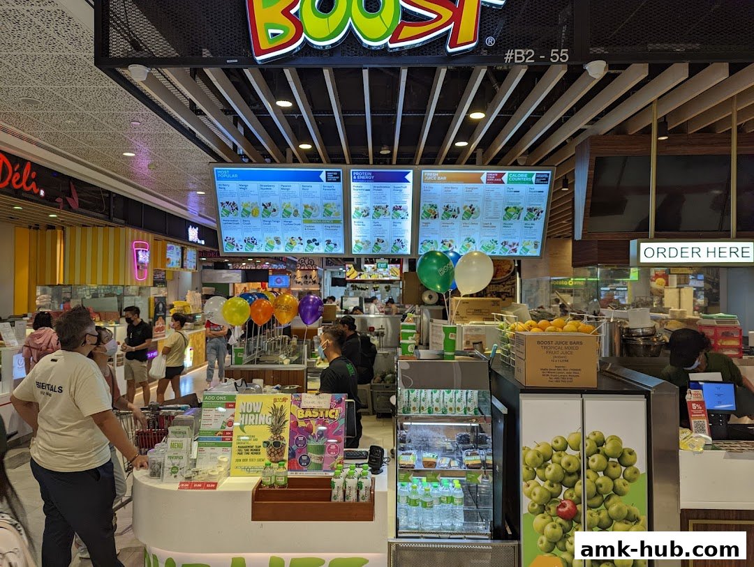 Boost Juice shop with bright menus, colorful balloons, and customers ordering.