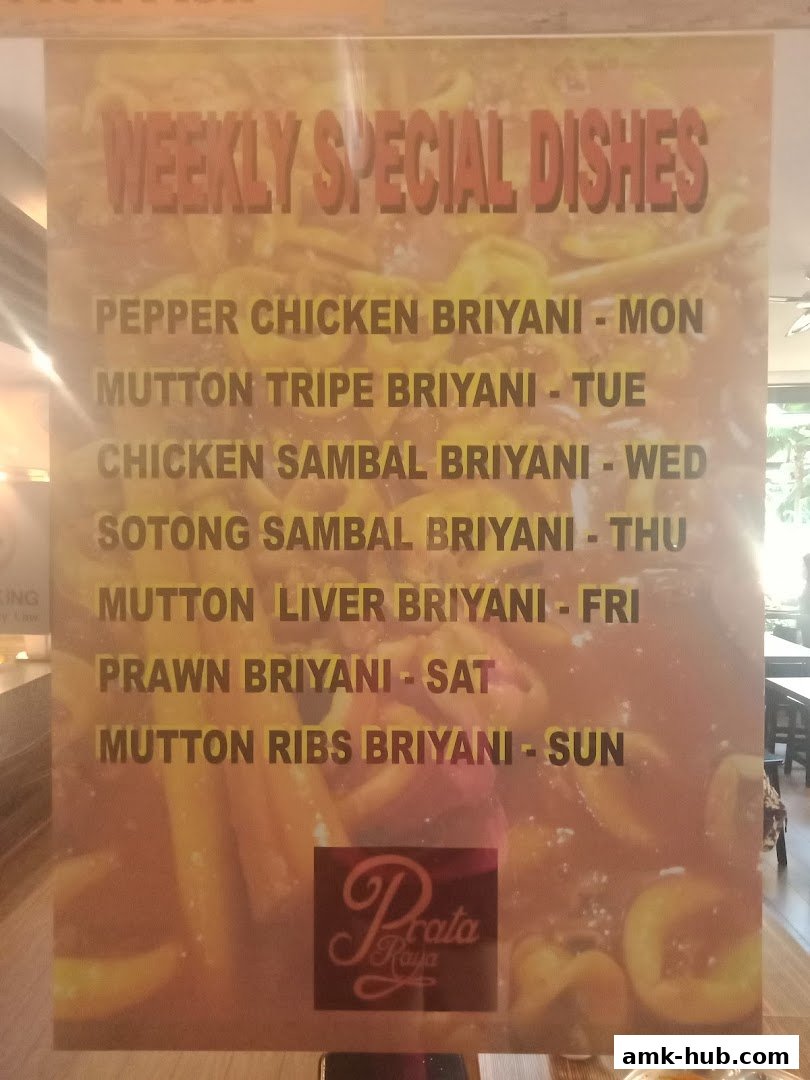 A sign displays weekly special biryani dishes offered by Prata Raya.