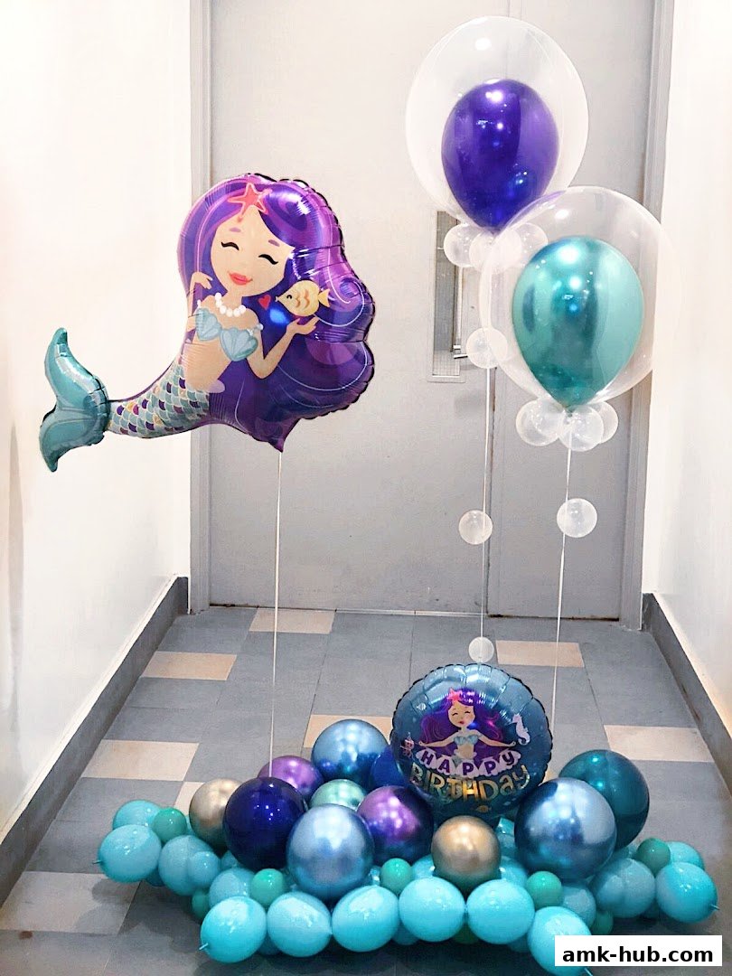 A festive balloon arrangement featuring a mermaid and a 'Happy Birthday' balloon.