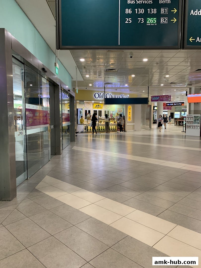 The Old Chang Kee shop front with customers and signage in a mall.