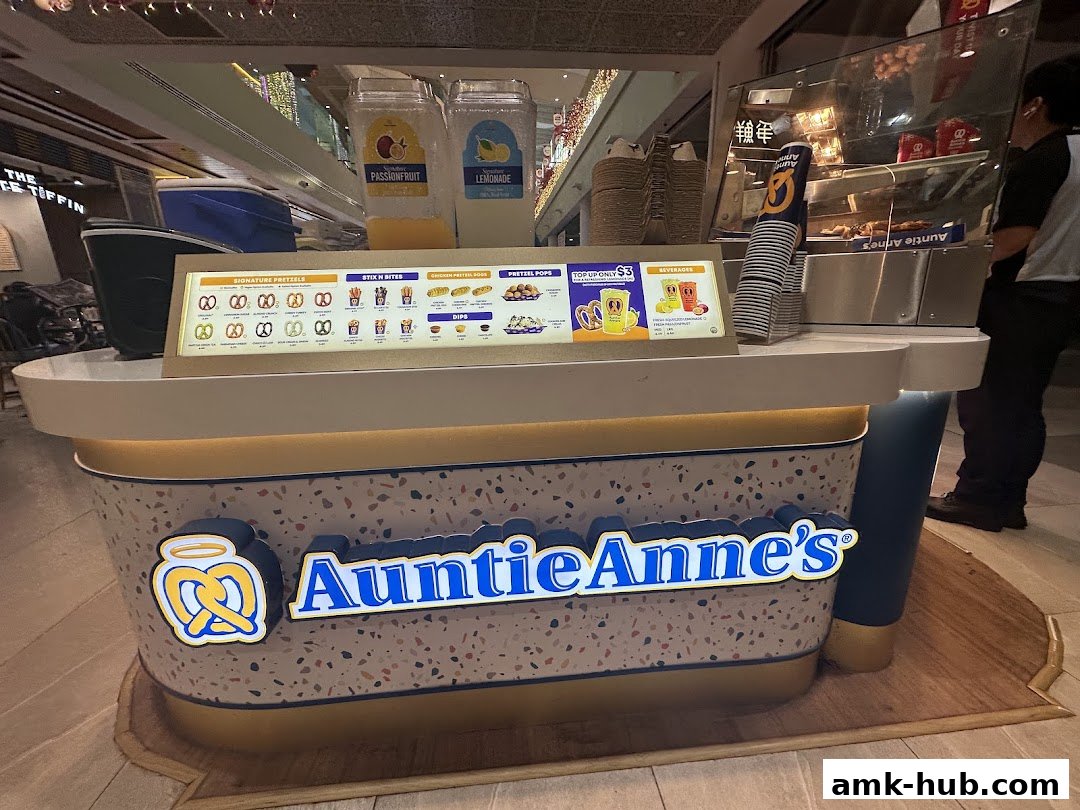 Auntie Anne's pretzel kiosk with a menu board displaying pretzels, dips, and beverages.