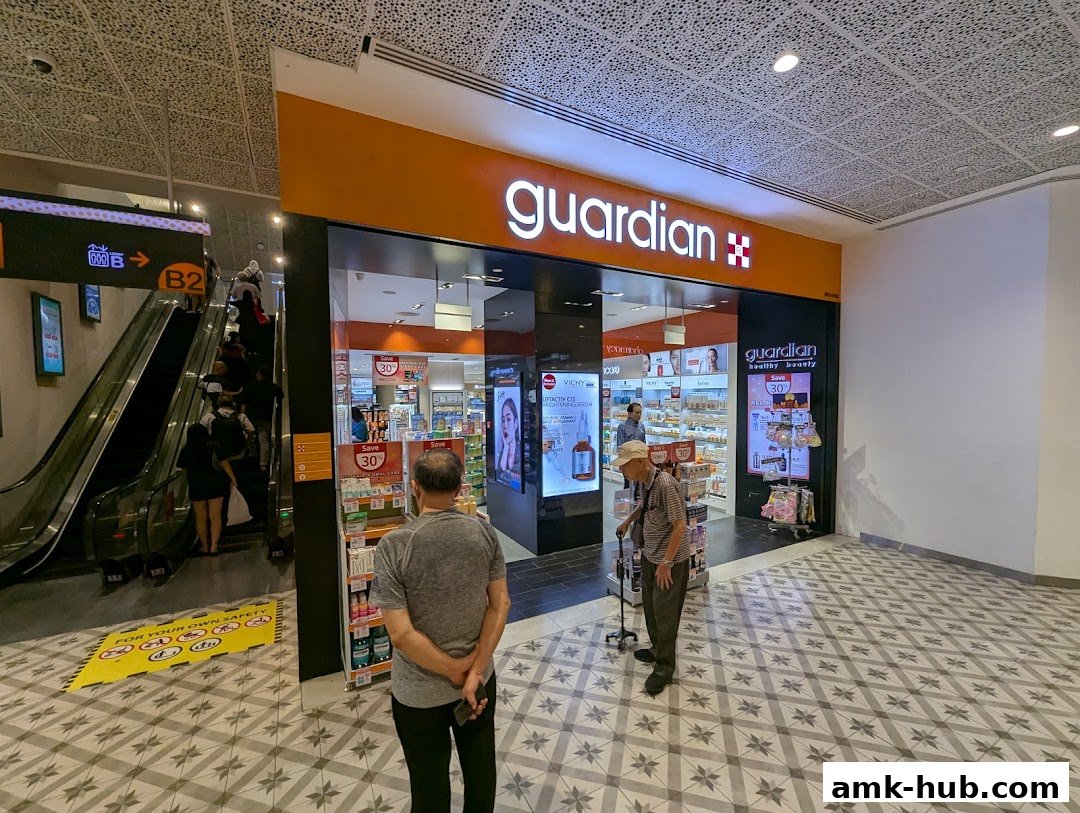 The Guardian Health & Beauty store entrance with promotional displays and customers.