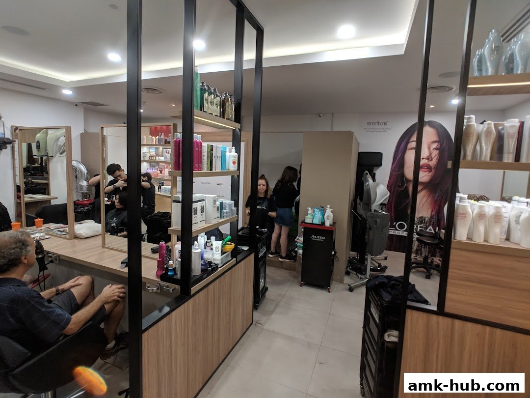 Interior of a modern hair salon with stylists working and shelves stocked with hair products.
