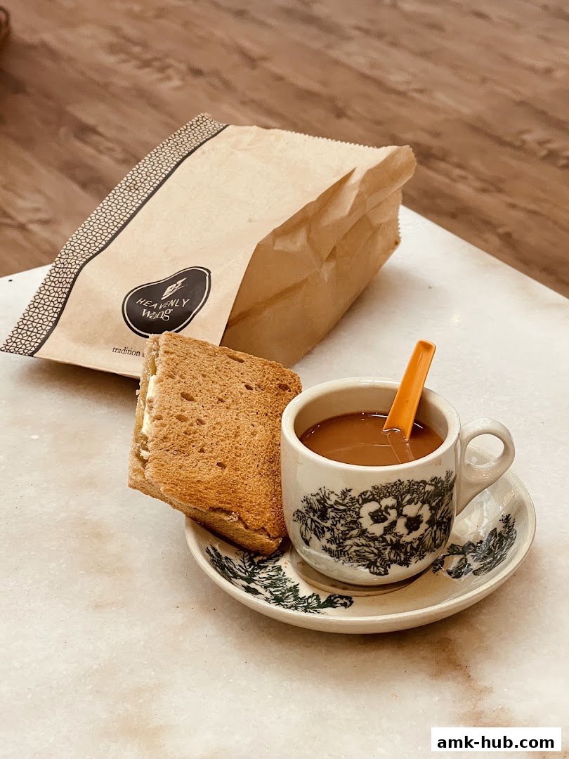 A cup of coffee and toast with butter served with a paper bag from Heavenly Wang.