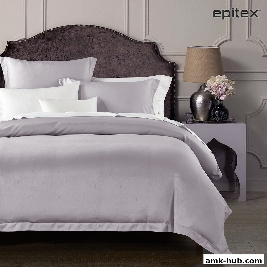 A beautifully made bed with Epitex bedding and a stylish headboard.