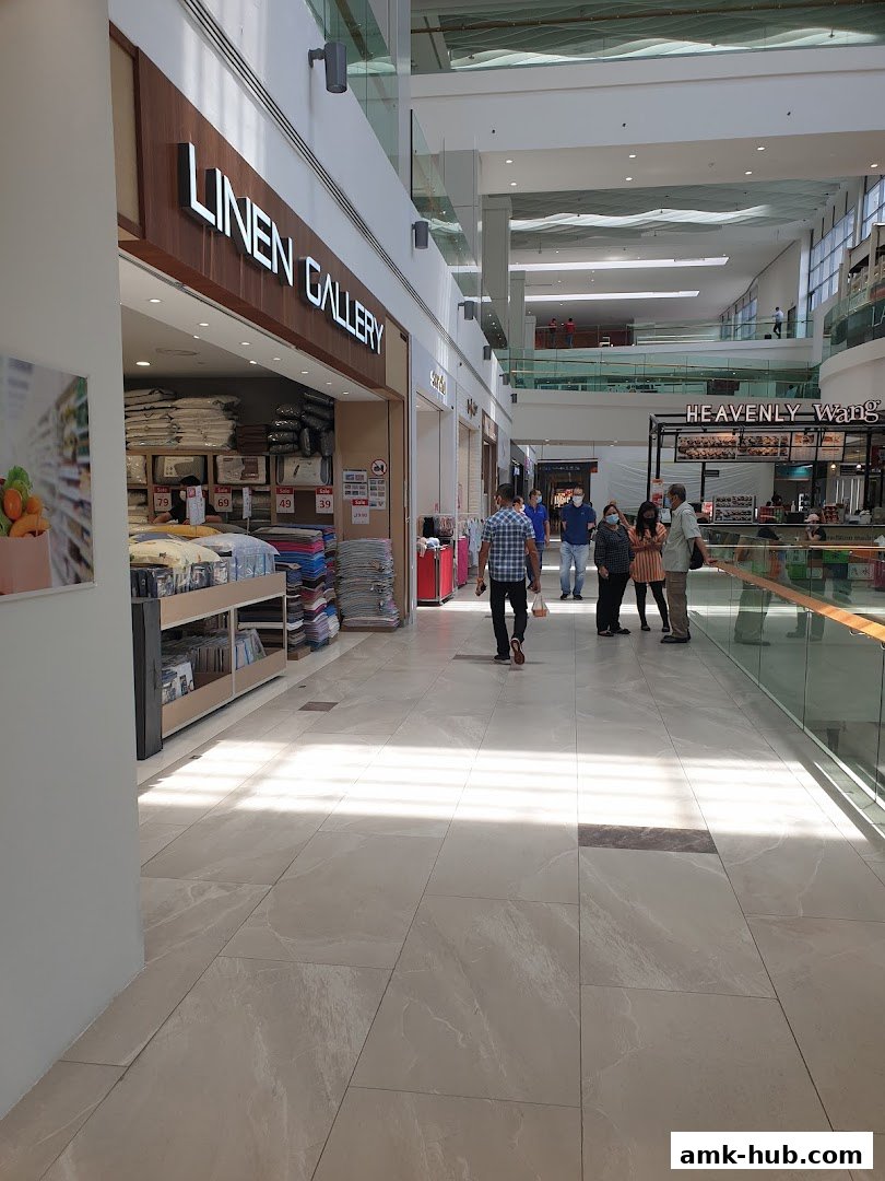 The exterior of the Linen Gallery shop in a mall, with bedding displayed inside.
