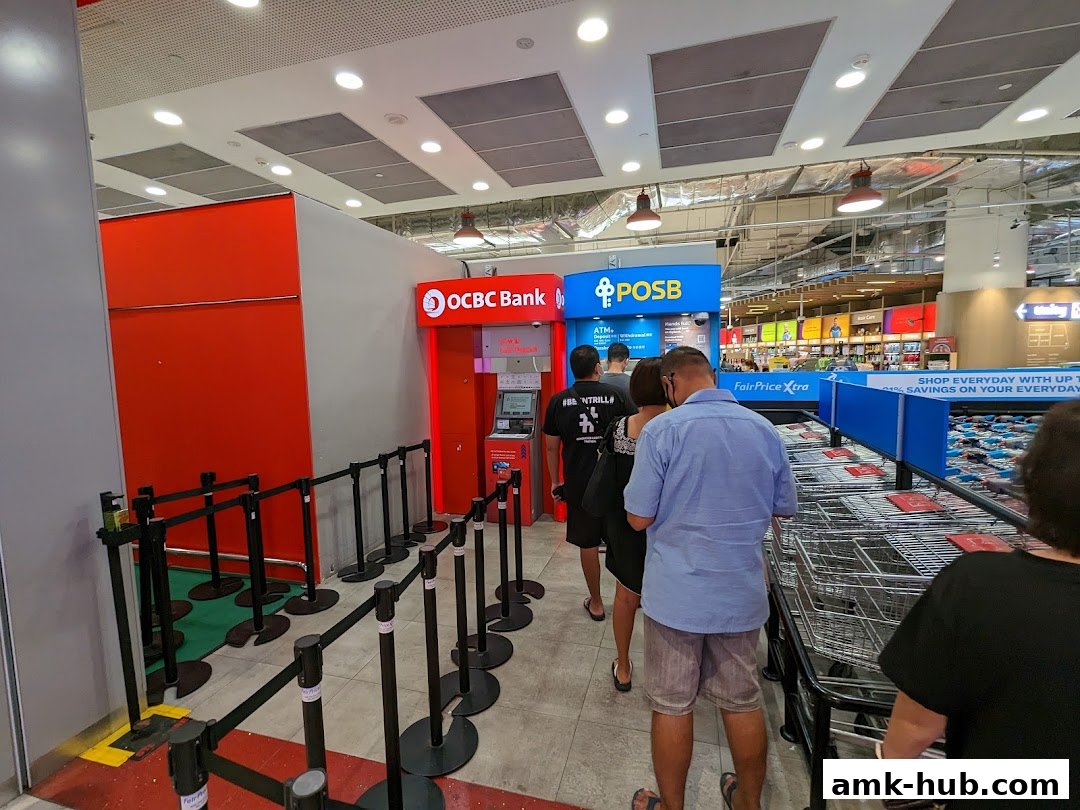 People queuing at OCBC and POSB ATMs inside a FairPrice Xtra supermarket.