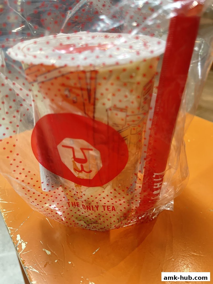 A LiHO TEA drink in a plastic bag with a red straw and logo.