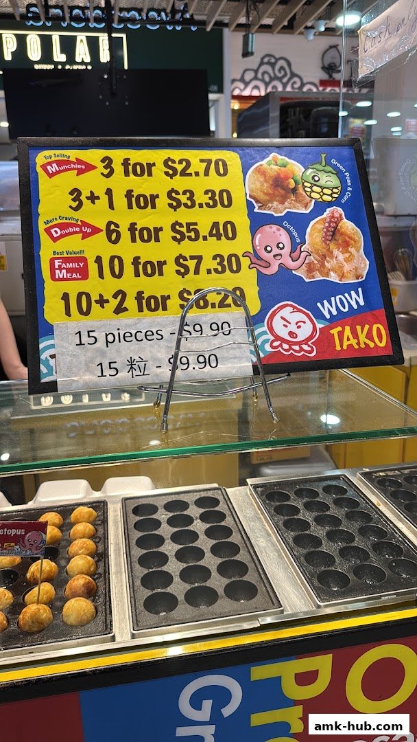 A menu board for Wow Tako showing prices for takoyaki pieces and combos.